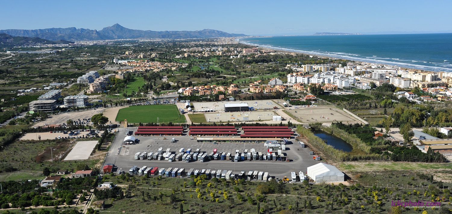 Fotografía aérea de Oliva Nova en 2012 con pistas, cuadras de techo rojo y la playa mediterránea